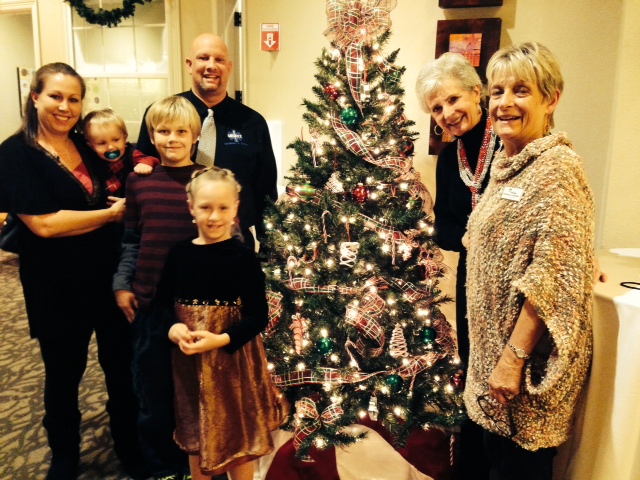 Daniel Doré and family, Betty Schleder with Honor Flight Austin, and me, Virginia Lazenby, around my Christmas Memories tree.